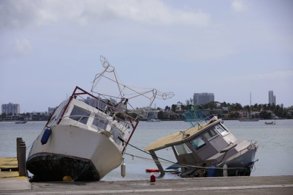 A boat is broken up and laying on its side.